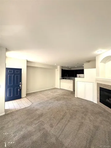 a view of an empty room with a fireplace and cabinets