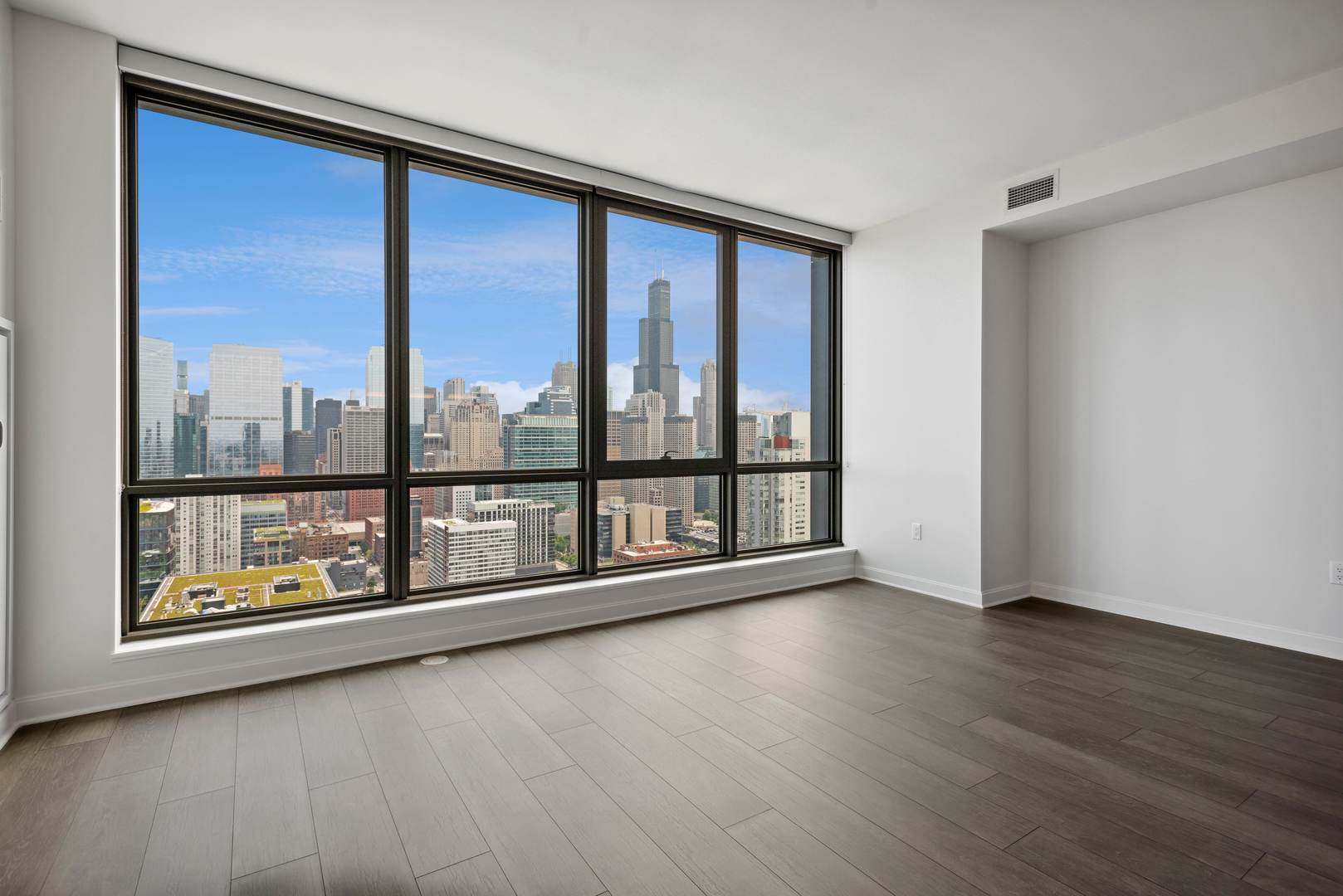 164 North Peoria Street, Unit 4004 Chicago, IL 60607 - Photo 25 of 32 a view of an empty room with wooden floor and a window