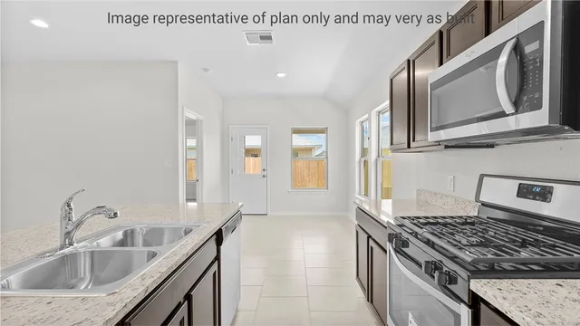 a kitchen with granite countertop a sink stove and cabinets