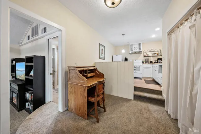 a kitchen with stainless steel appliances granite countertop a stove a sink dishwasher and white cabinets with wooden floor