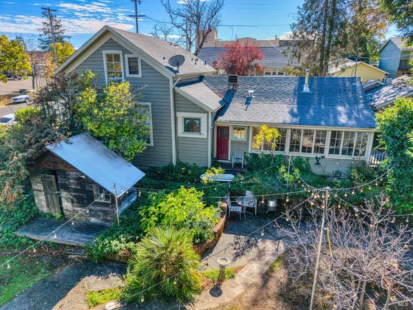 an aerial view of a house with a yard and large tree