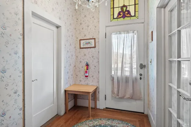 a view of a hallway with wooden floor and entryway