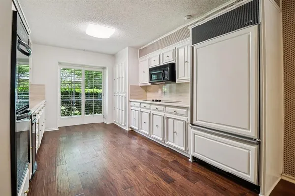 a kitchen with cabinets stainless steel appliances a sink and wooden floor