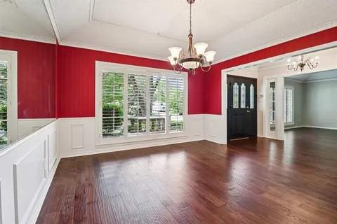 an empty room with windows and ceiling fan