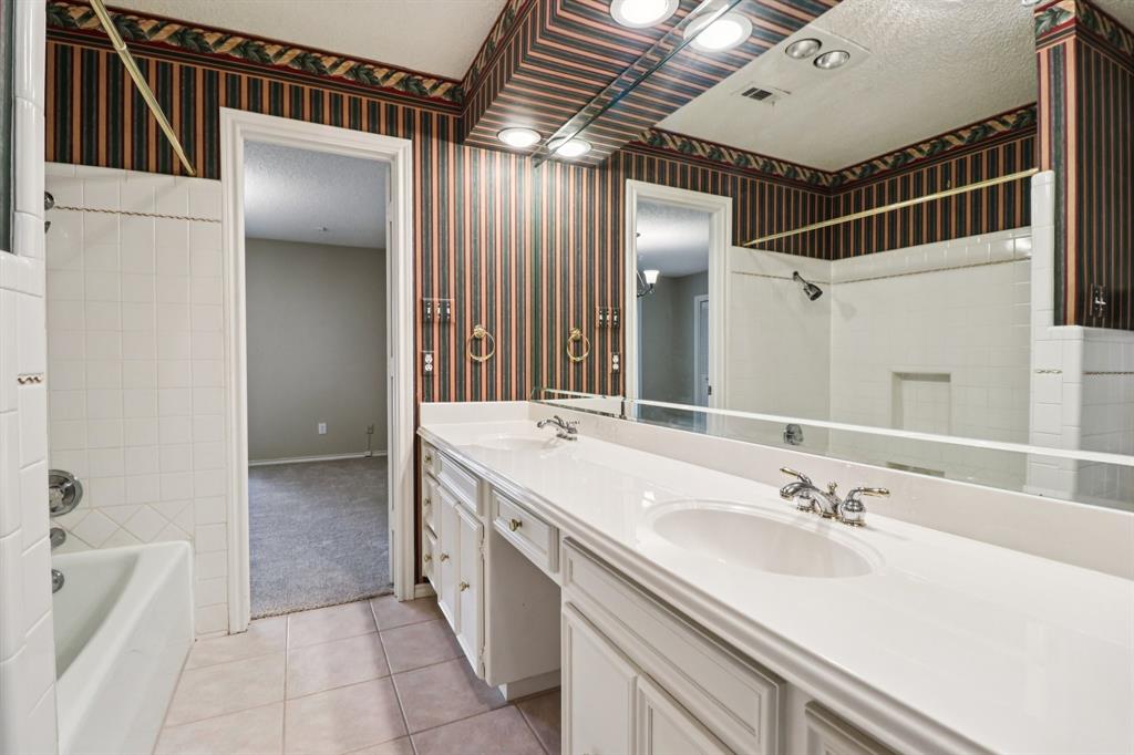 1015 Crowley Road Arlington, TX 76012 - Photo 25 of 36 a bathroom with a double vanity sink a mirror and a bathtub