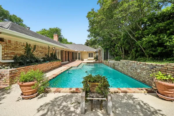 a view of a house with a big yard and large trees