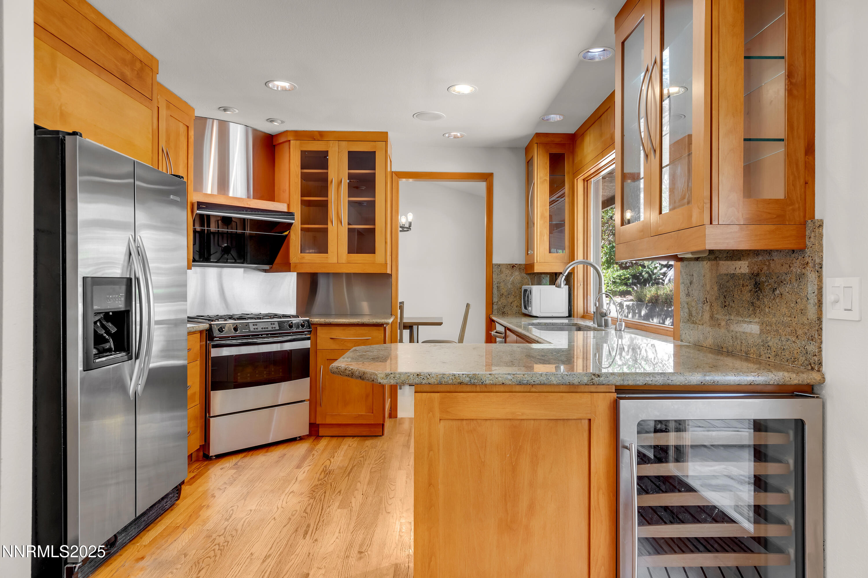 2593 Chaparral Court Reno, NV 89509 - Photo 9 of 37 a kitchen with stainless steel appliances granite countertop a refrigerator a stove and a sink with wooden floor