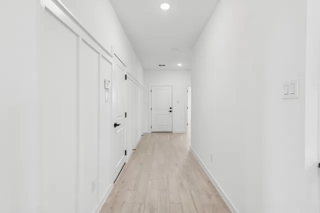 a view of a hallway with wooden floor