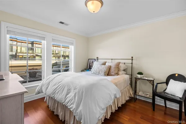 a bedroom with bed and wooden floor