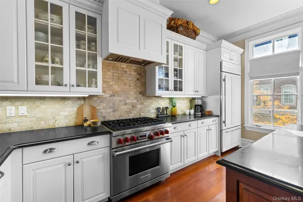 a kitchen with stainless steel appliances granite countertop a stove and a white cabinets
