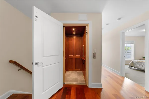 a view of a hallway with wooden floor and furniture