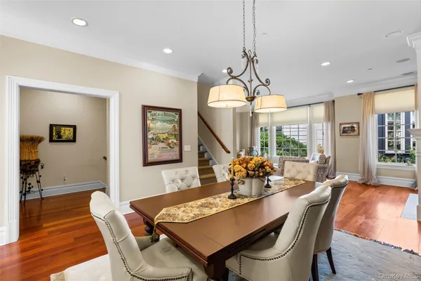 a dining room with furniture a chandelier and wooden floor