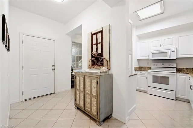 a kitchen with white cabinets and white appliances