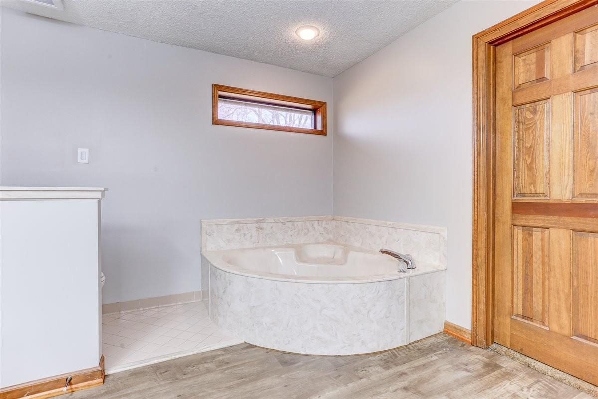 3915 Oak Road Bartlett, TN 38135 - Photo 10 of 28 Bathroom with a textured ceiling, a garden tub, and light wood-style floors