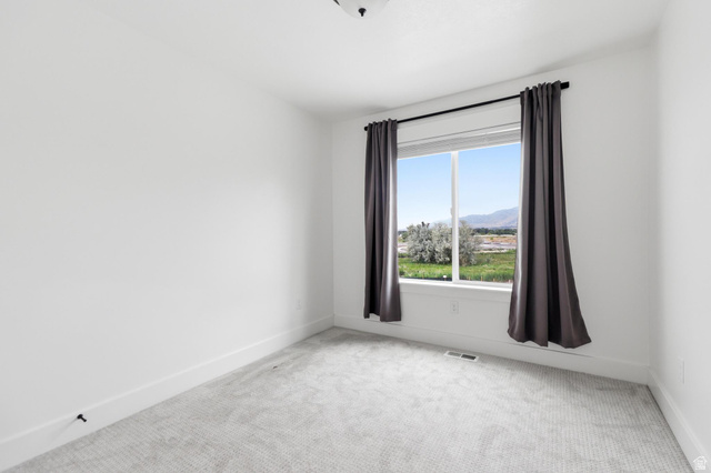 347 Ropelato Drive Logan, UT 84321 - Photo 29 of 46 Bright room featuring white walls, gray patterned carpeting, a large window, and white trim