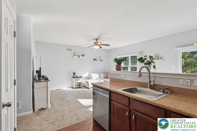 a kitchen with a refrigerator a stove top oven a sink and dishwasher with wooden floor