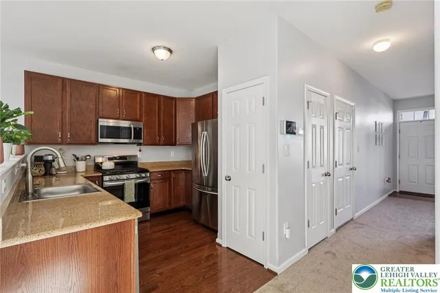 a kitchen with kitchen island granite countertop a sink stainless steel appliances and cabinets