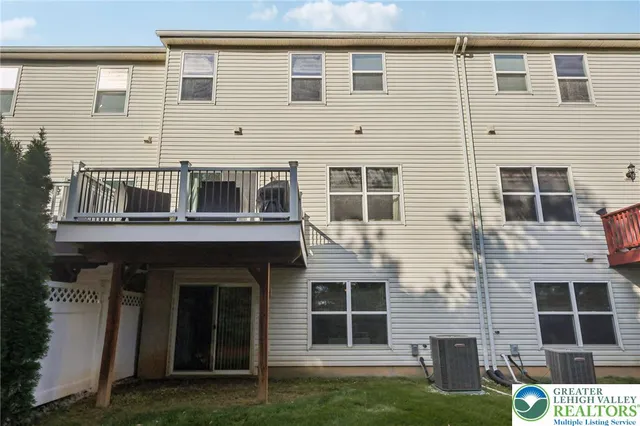 a view of a white house next to a yard