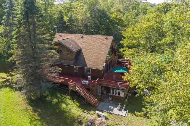 an aerial view of a house with a yard swimming pool and outdoor seating