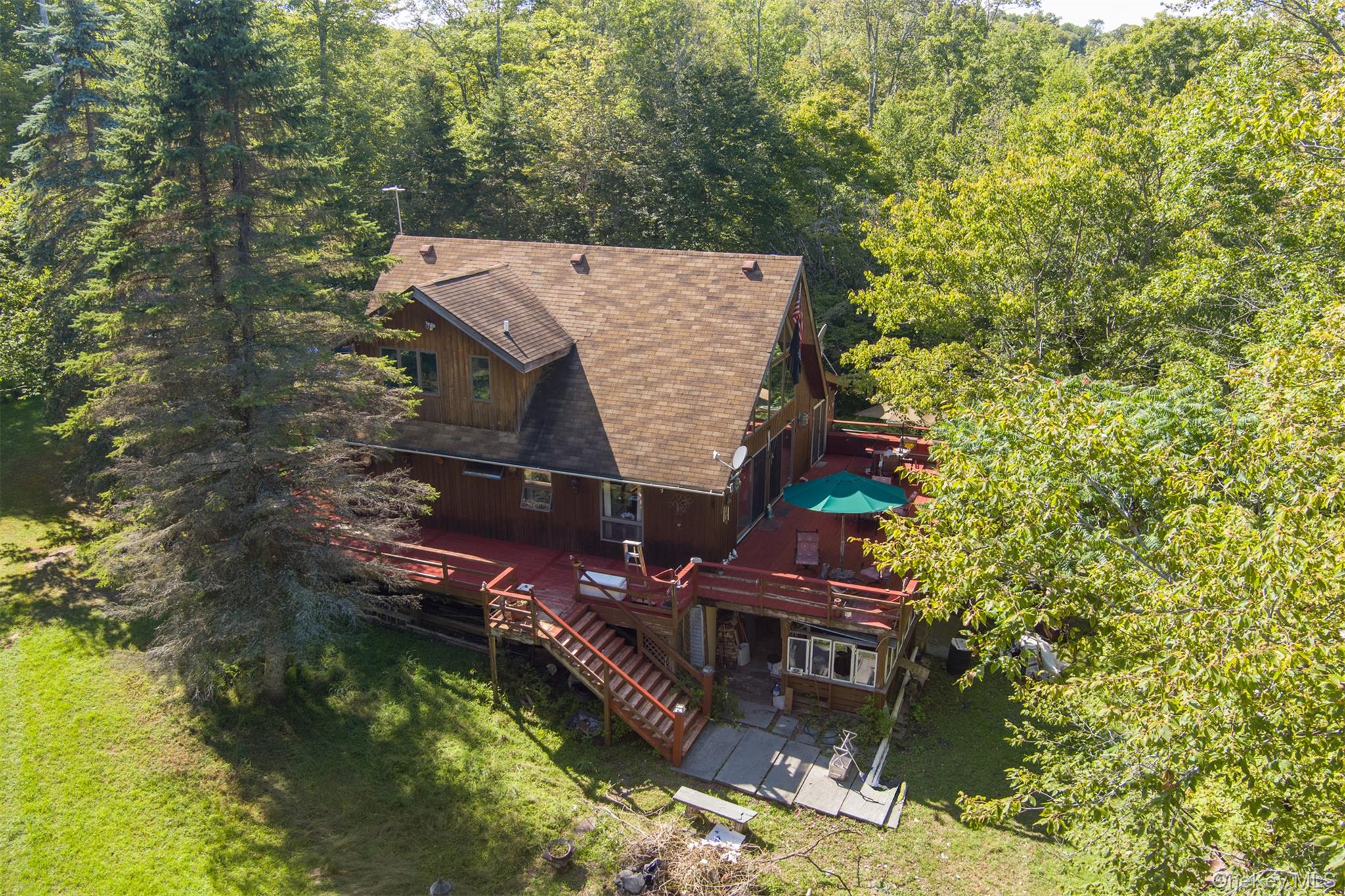 an aerial view of a house with a yard swimming pool and outdoor seating