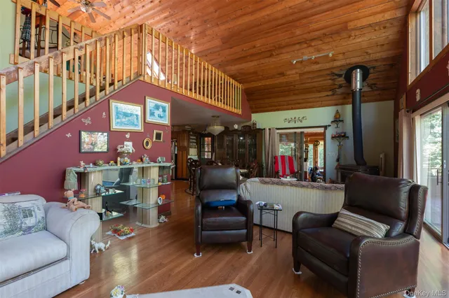 a living room with furniture a flat screen tv and a large window