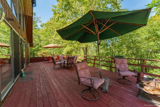 a view of deck with table and chairs under an umbrella with wooden floor
