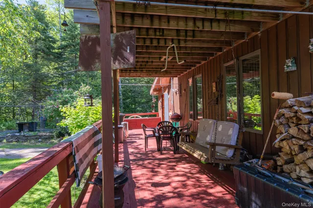 a view of the patio with couches and a dining table and chairs with wooden floor