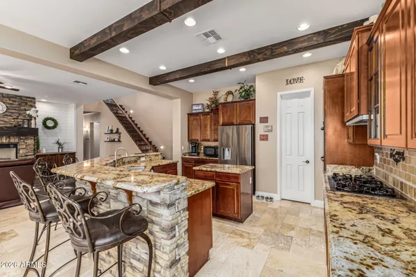 a kitchen with granite countertop wooden cabinets and stainless steel appliances