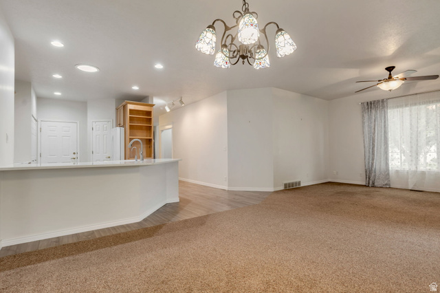 1092 Tithing Ridge Drive Riverton, UT 84065 - Photo 5 of 25 Open living area featuring recessed lighting, a decorative chandelier, a ceiling fan, and mixed flooring with wood-finish planks and carpet. ROOM for barstools
