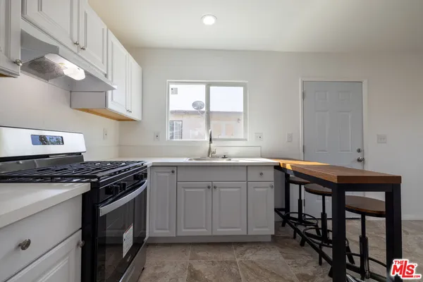 a kitchen with a sink stove and cabinets