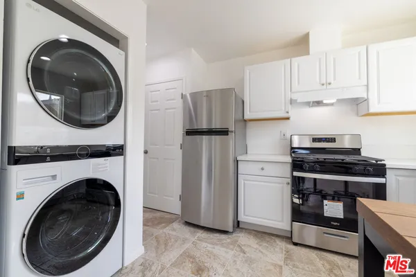 a kitchen with stainless steel appliances granite countertop a refrigerator and a stove top oven