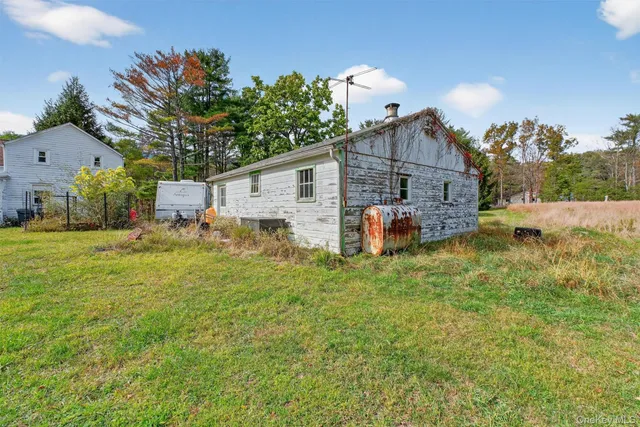 a front view of house with yard and trees in the background