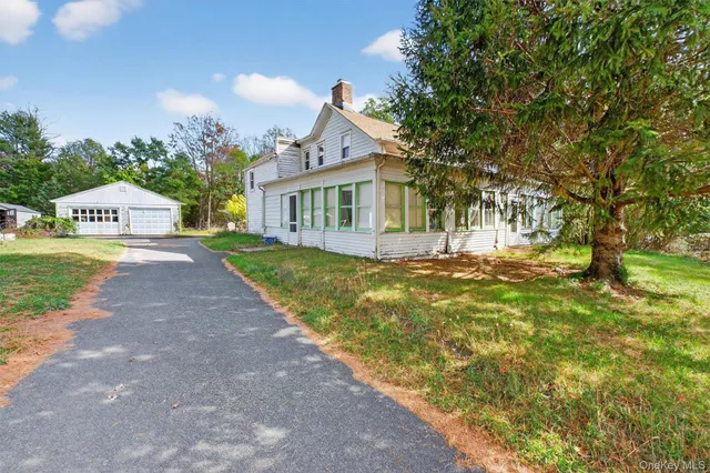 a front view of a house with a yard and trees