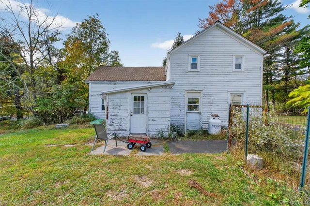 a view of a house with backyard and chairs