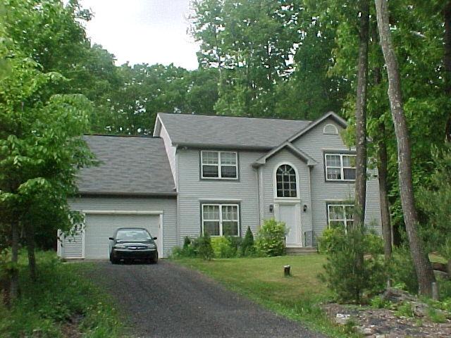 17 Tara Hill Road Bartonsville, PA 18321 - Photo 1 of 1 a front view of a house with a garden and trees