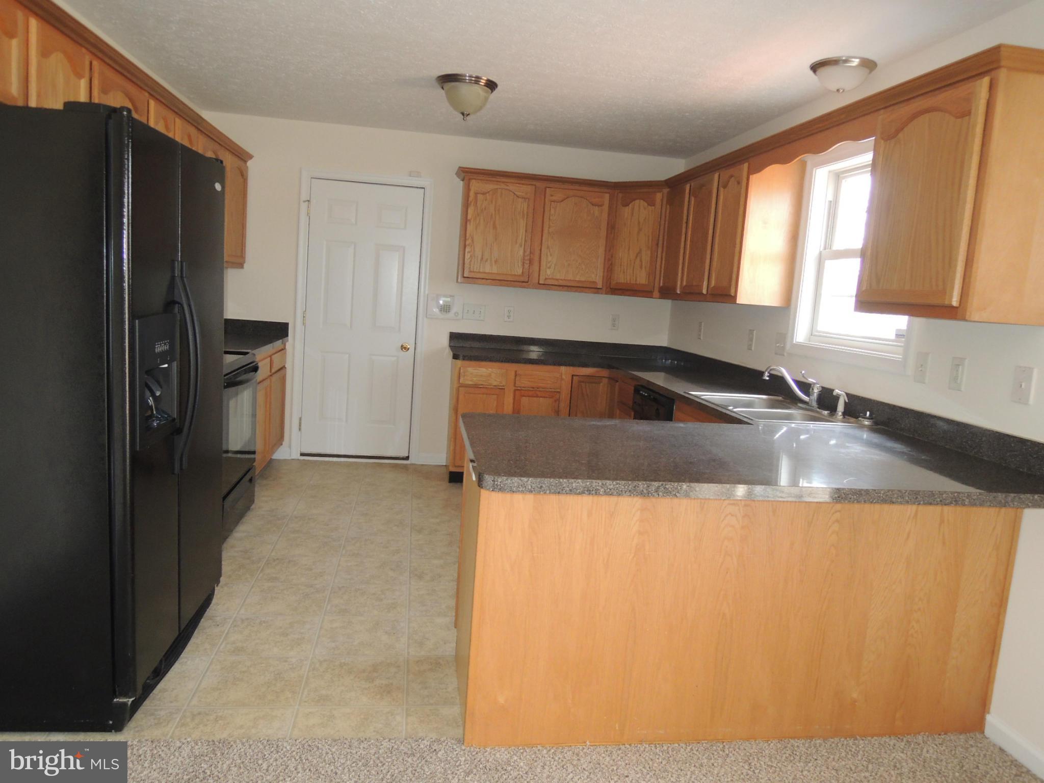 39 Raft Court Inwood, WV 25428 - Photo 11 of 30 a kitchen with granite countertop a refrigerator and a sink