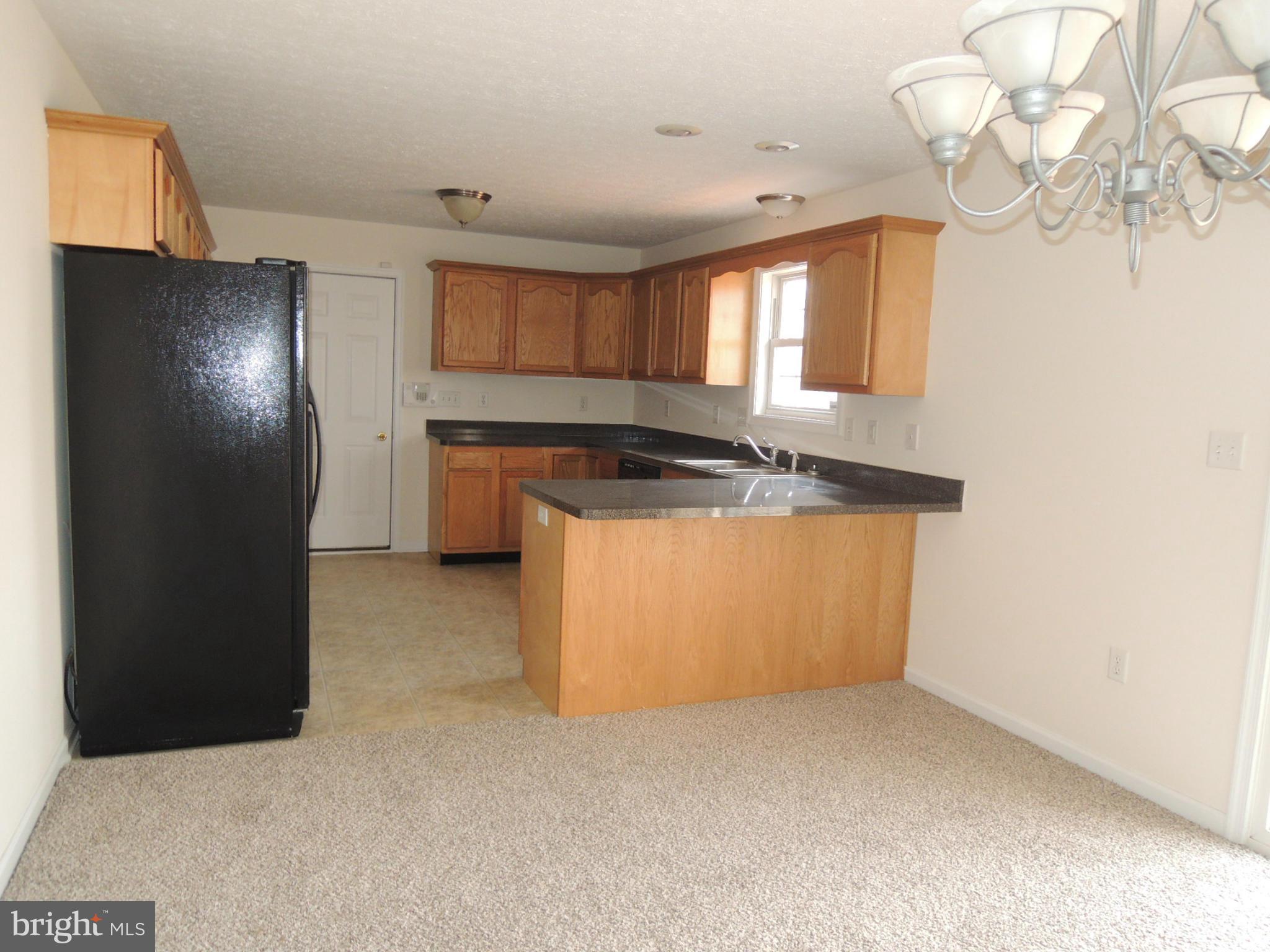 39 Raft Court Inwood, WV 25428 - Photo 8 of 30 a kitchen with granite countertop a refrigerator a sink a stove and cabinets