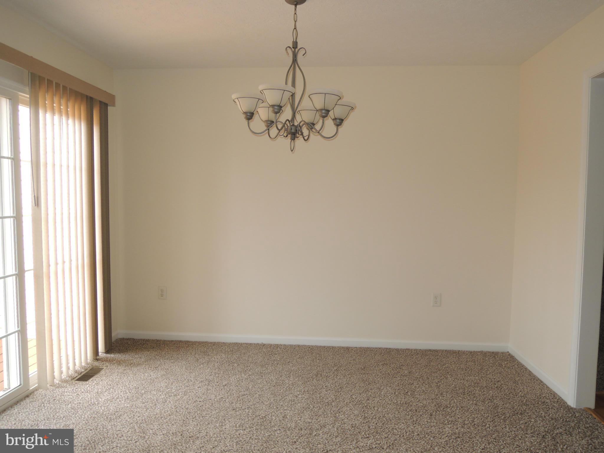 39 Raft Court Inwood, WV 25428 - Photo 9 of 30 an empty room with windows and chandelier