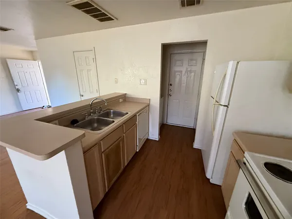 a kitchen with sink a refrigerator and washer
