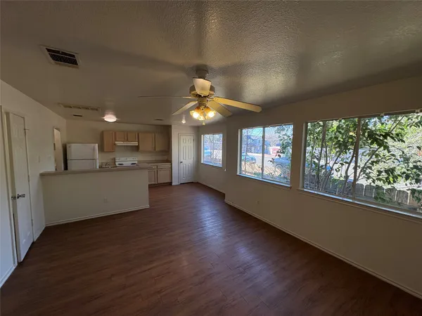 a view of a living room and kitchen with furniture wooden floor and windows