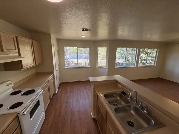 a kitchen that has a sink stove and cabinets