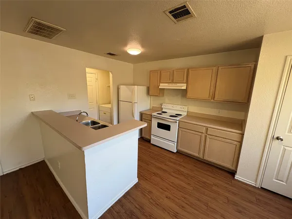a kitchen with a stove a sink and a refrigerator