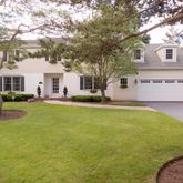 a front view of a house with a yard and trees