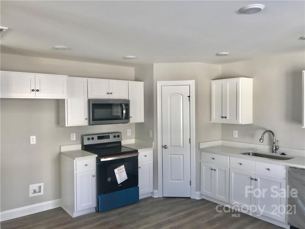 1007 3rd Street Spencer, NC 28159 - Photo 4 of 12 a kitchen with stainless steel appliances a stove sink microwave and cabinets
