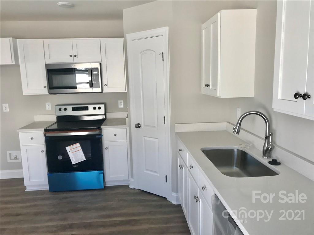 1007 3rd Street Spencer, NC 28159 - Photo 5 of 12 a kitchen with stainless steel appliances granite countertop a white stove a sink a refrigerator and a microwave