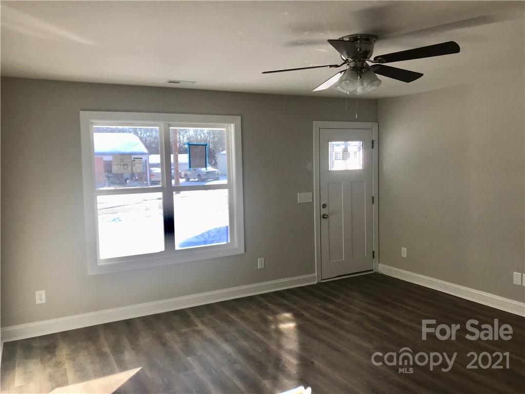 1007 3rd Street Spencer, NC 28159 - Photo 8 of 12 an empty room with wooden floor fan and windows