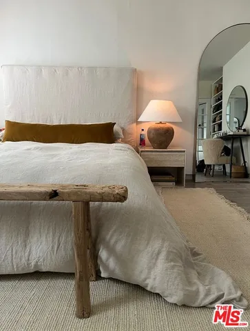 a bedroom with a bed and a mirror