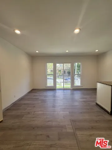 a view of a two chairs and table in the back yard of the house