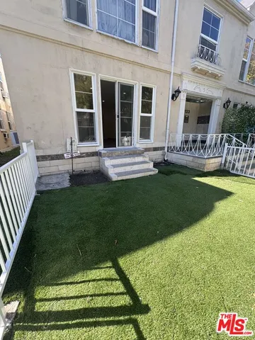 a view of house with backyard and outdoor seating