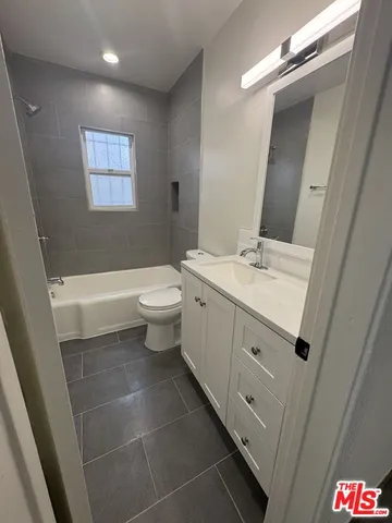 a view of an empty room with wooden floor and windows